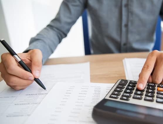 An accountant working through invoices with a calculator