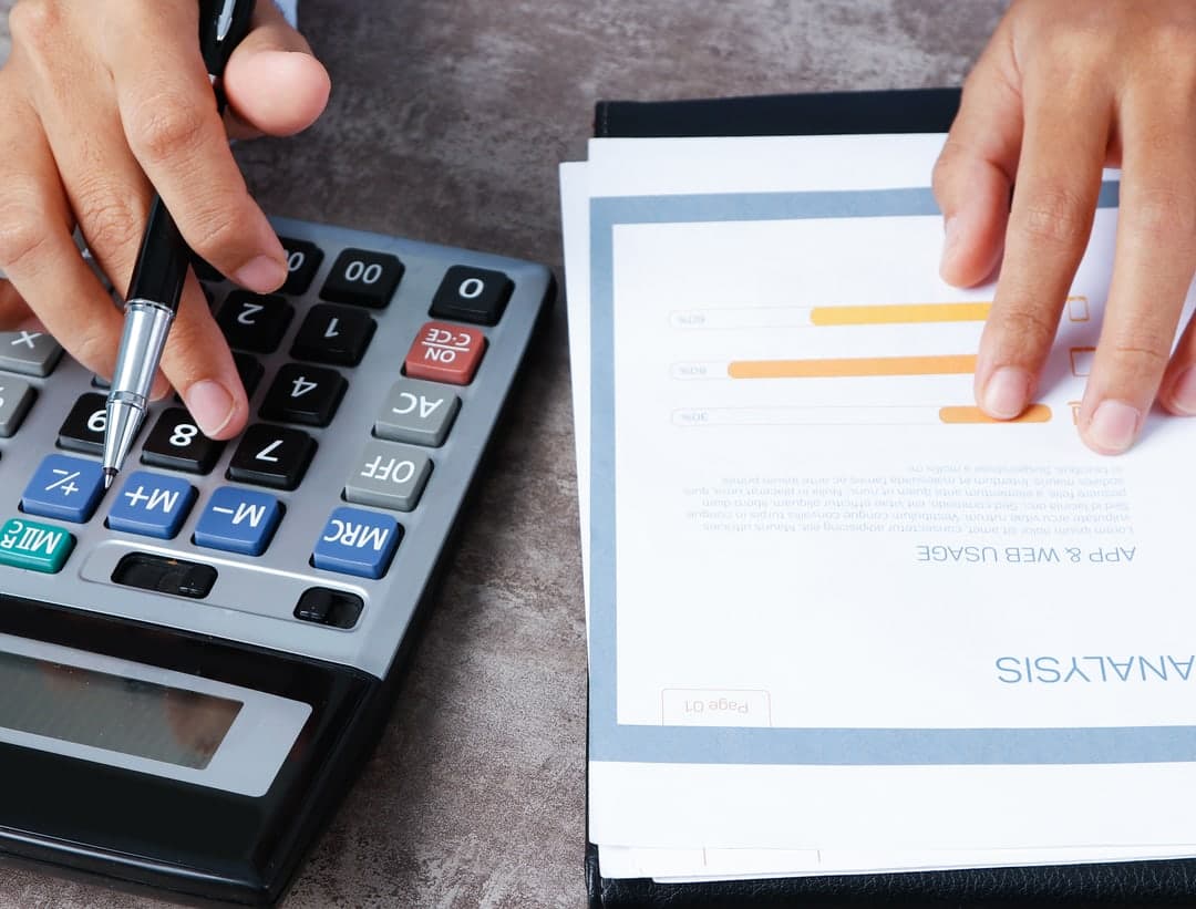 An analyst checking a report with a calculator